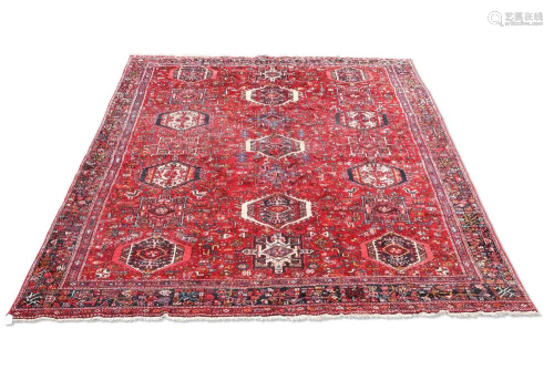 A PERSIAN HERIZ CARPET, the red field with three columns of ...