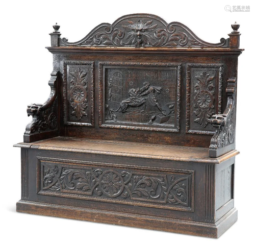 A VICTORIAN CARVED OAK BOX SETTLE, profusely carved with mas...