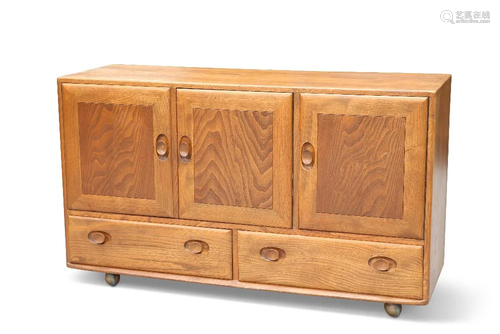 AN ERCOL LIGHT ELM SIDEBOARD, with three cupboard doors abov...