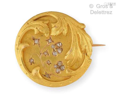 Broche circulaire en or jaune, composée d’une plaque ciselée...