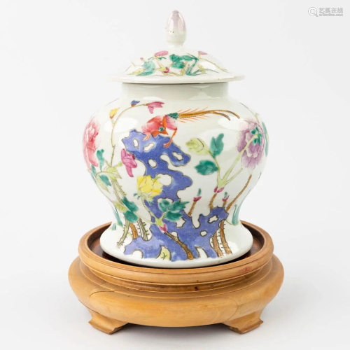 A Chinese jar with a lid made of porcelain with a flower dec...