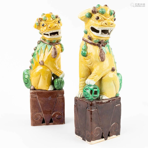 A pair of Chinese Foo dogs made of glazed stoneware. (29,5 c...