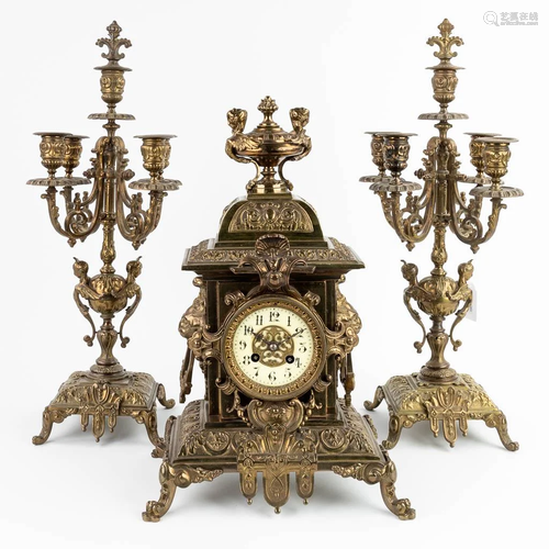 A three-piece mantle garniture clock and candelabra, made of...