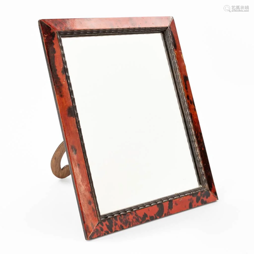 A decorative mirror or picture frame finished with a tortois...