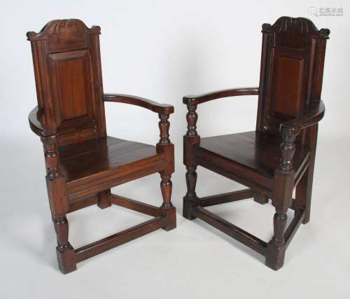 A pair of 18th / 19th century oak cacqueteuse armchairs, one...
