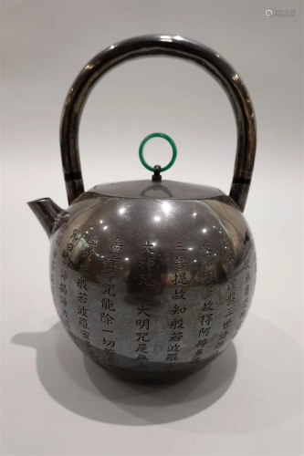 A silver teapot with XinJing carving.