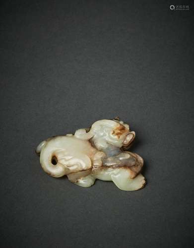 A RARE PALE WHITE AND RUSSET JADE CARVING OF A MYTHICAL BEAS...