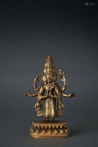 A GILT-BRONZE FIGURE OF AN ELEVEN-HEADED AVALOKITSEVARA, QIN...