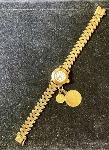 Une montre bracelet de dame en or jaune agrémenté de pièces ...