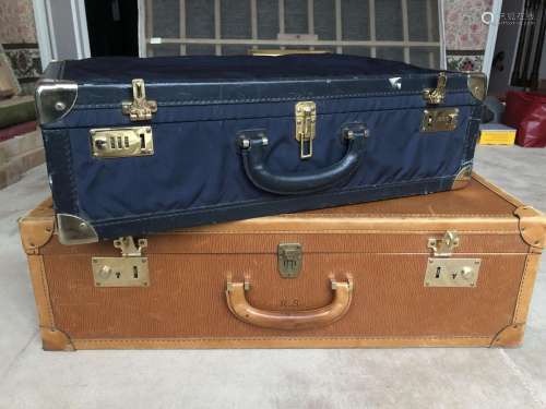 Deux valises, une tendue de cuir fauve grainé et l'autre...