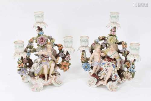 Pair of Sitzendorf porcelain three-branch figural candelabra...