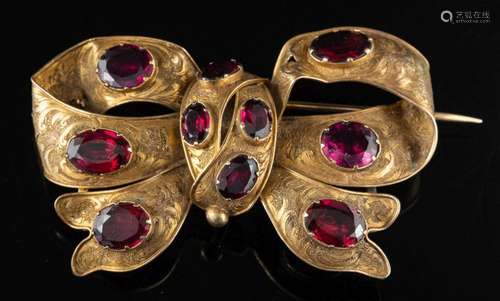 A late Victorian garnet ribbon bow brooch,: set with oval cu...