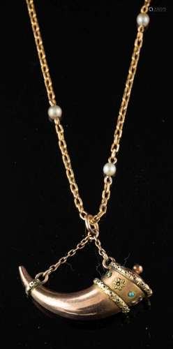 A gold coloured cornucopia pendant,: on a seed pearl set cha...