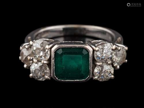 An emerald and diamond ring: the square cut emerald in a col...