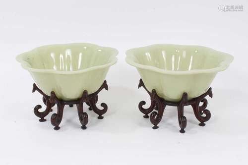 Pair of Chinese Peking glass lobed green bowls on wooden sta...