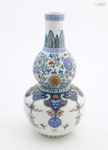 A Chinese double gourd vase with doucai style decoration wit...