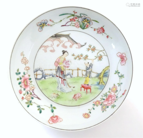A Chinese famille rose plate decorated with a woman holding ...