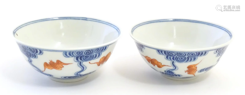 A pair of Chinese bowls decorated with stylised bats amongst...