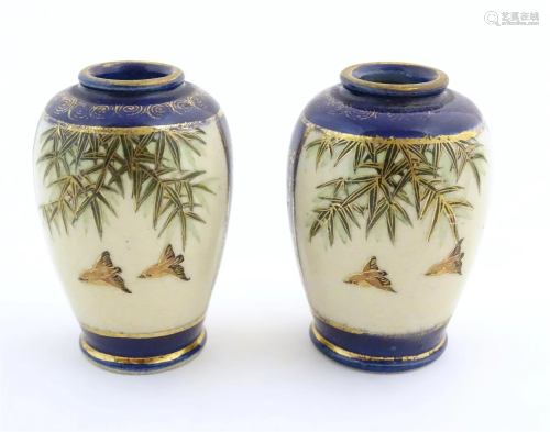 A pair of small Japanese vases decorated with birds and foli...