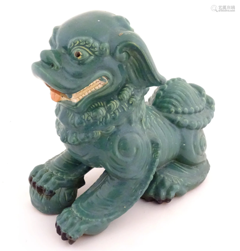 An Oriental model of a guardian lion with a turquoise glaze....