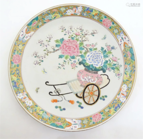 A Chinese famille rose charger depicting a cart carrying a v...