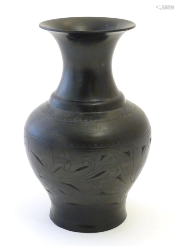 An Oriental black vase of baluster form with a flared rim an...