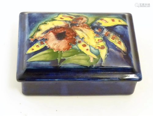 A Moorcroft lidded box of rectangular form in the Orchid pat...