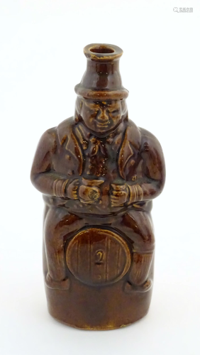 A Victorian treacle glazed spirit flask modelled as Old Tom,...