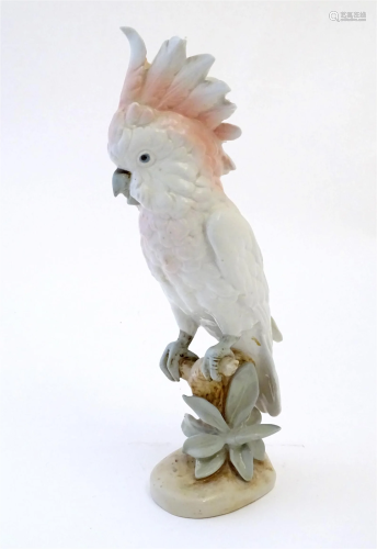 A Royal Dux model of a cockatoo bird perched on a branch. Ma...