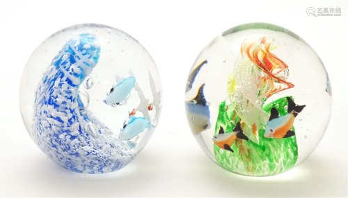 Two glass paperweights , one with fish decoration in the man...