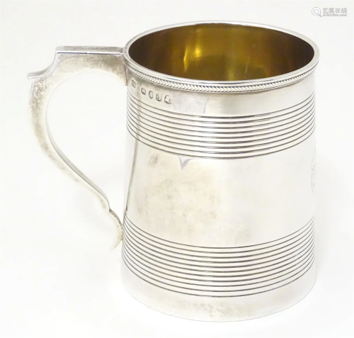 A George III silver mug of tankard form with banded decorati...
