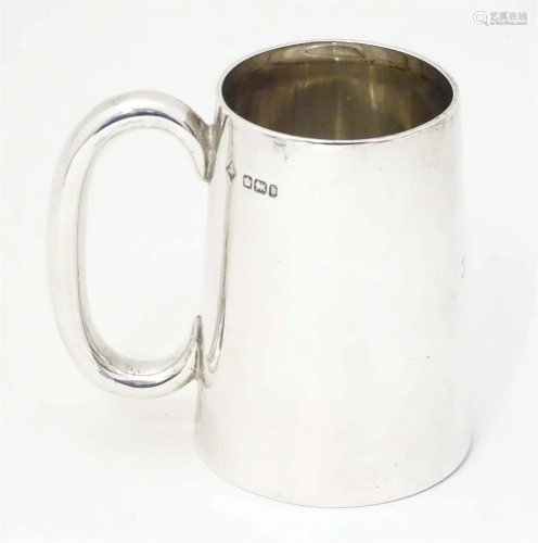 A silver mug of tankard form, hallmarked Sheffield 1900, mak...