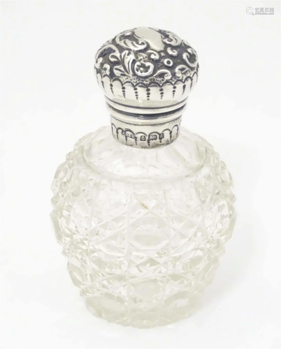 A cut glass perfume / scent bottle with silver mount and lid...