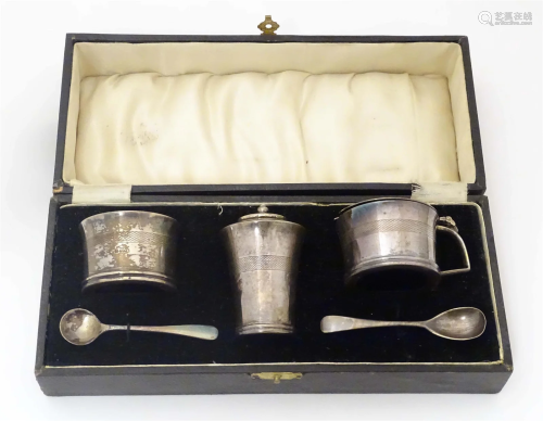 An Art Deco three piece silver cruet set comprising mustard ...