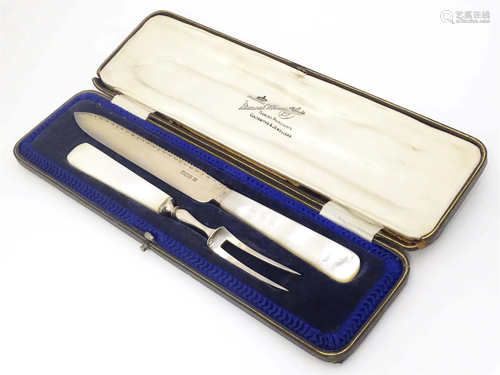 A cased carving knife and fork with mother of pearl handles,...