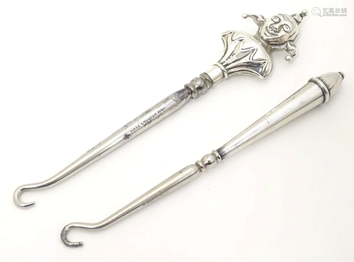 Two silver handled button hooks. One formed as a jester hall...