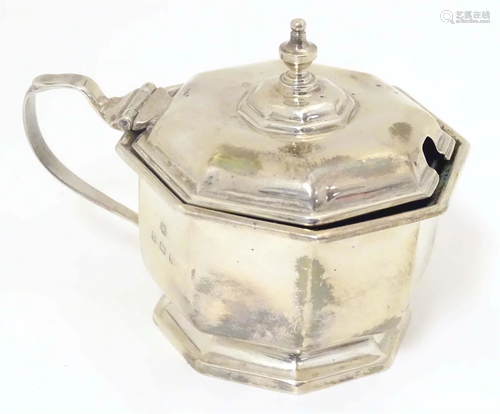 A silver mustard pot of octagonal form with blue glass liner...