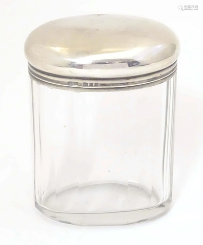 A glass dressing table jar of oval form with facet detail an...