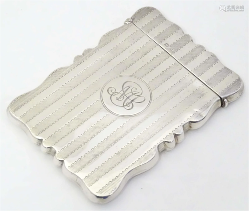 A silver card case with banded engine turned decoration. Hal...