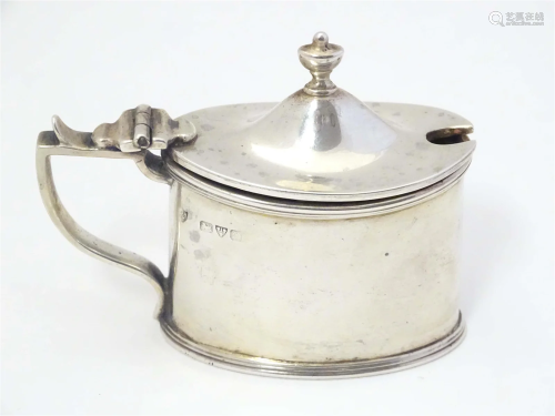 A silver mustard pot of neo classical design with blue glass...