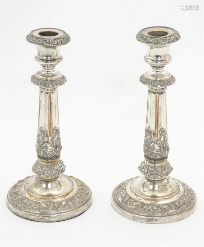 A pair of silver plate candlesticks with acanthus scroll dec...