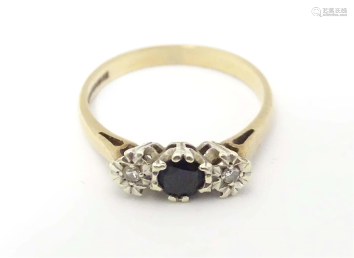A 9ct gold ring set with central spinel flanked by diamonds....