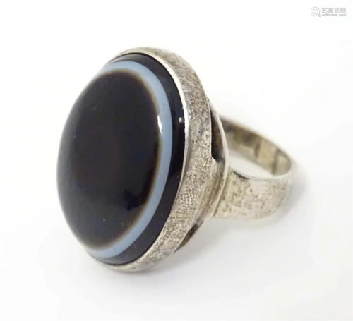 A silver ring set with banded agate cabochon to top, hallmar...