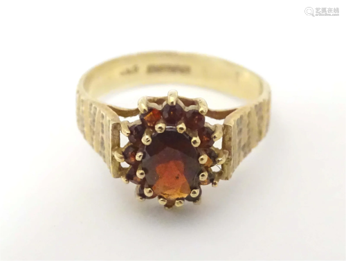 A 9ct gold retro c. 1975 ring set with garnet cluster with e...