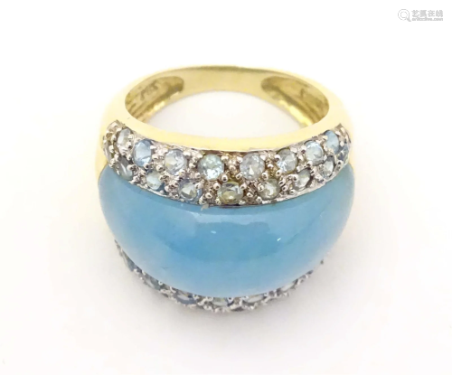 A yellow metal ring set with aqua blue jadite and blue tourm...