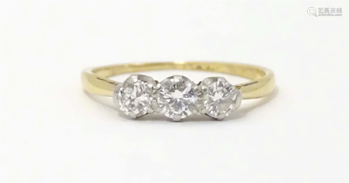 An 18ct gold rings set with a trio of diamonds. Ring size ap...
