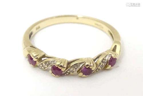 A 9ct gold ring set with rubies and diamonds in a linear set...