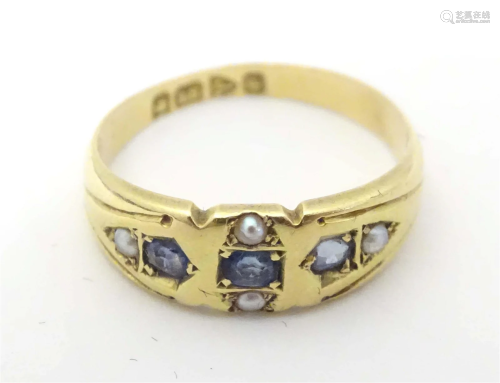 A Victorian 18ct gold ring set with blue stones and seed pea...