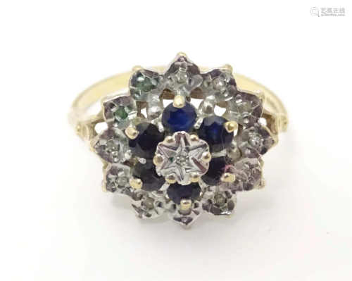 A 9ct gold ring set with sapphires and diamonds in a cluster...