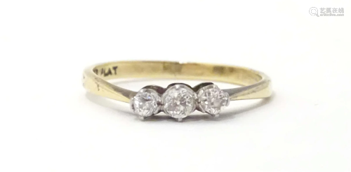 An 18ct gold ring set with three graduated diamonds in a pla...